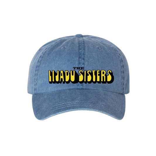 Horizon Unlimited Hat in faded royal blue with bold yellow and black embroidered text "The Lijadu Sisters" on front