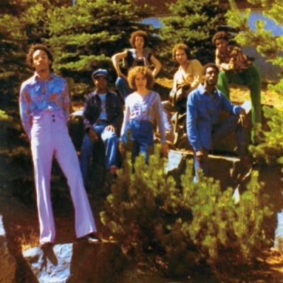 Group of musicians posing outdoors among trees and rocks for If You See Me b/w Games vinyl record cover.