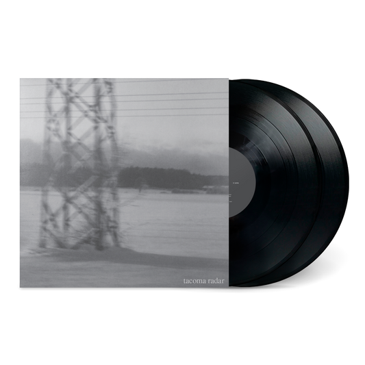 Black vinyl records partially pulled out from a gray cover with a blurry tower image for No One Waved Goodbye.