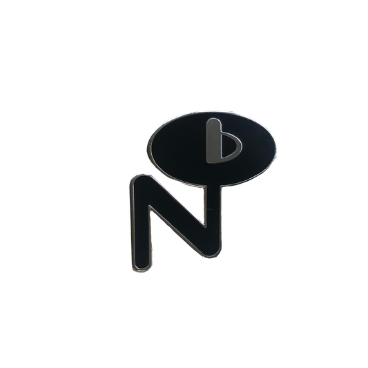 Black and silver enamel pin with abstract design featuring letter N and speech bubble shape labeled Enamel Pin